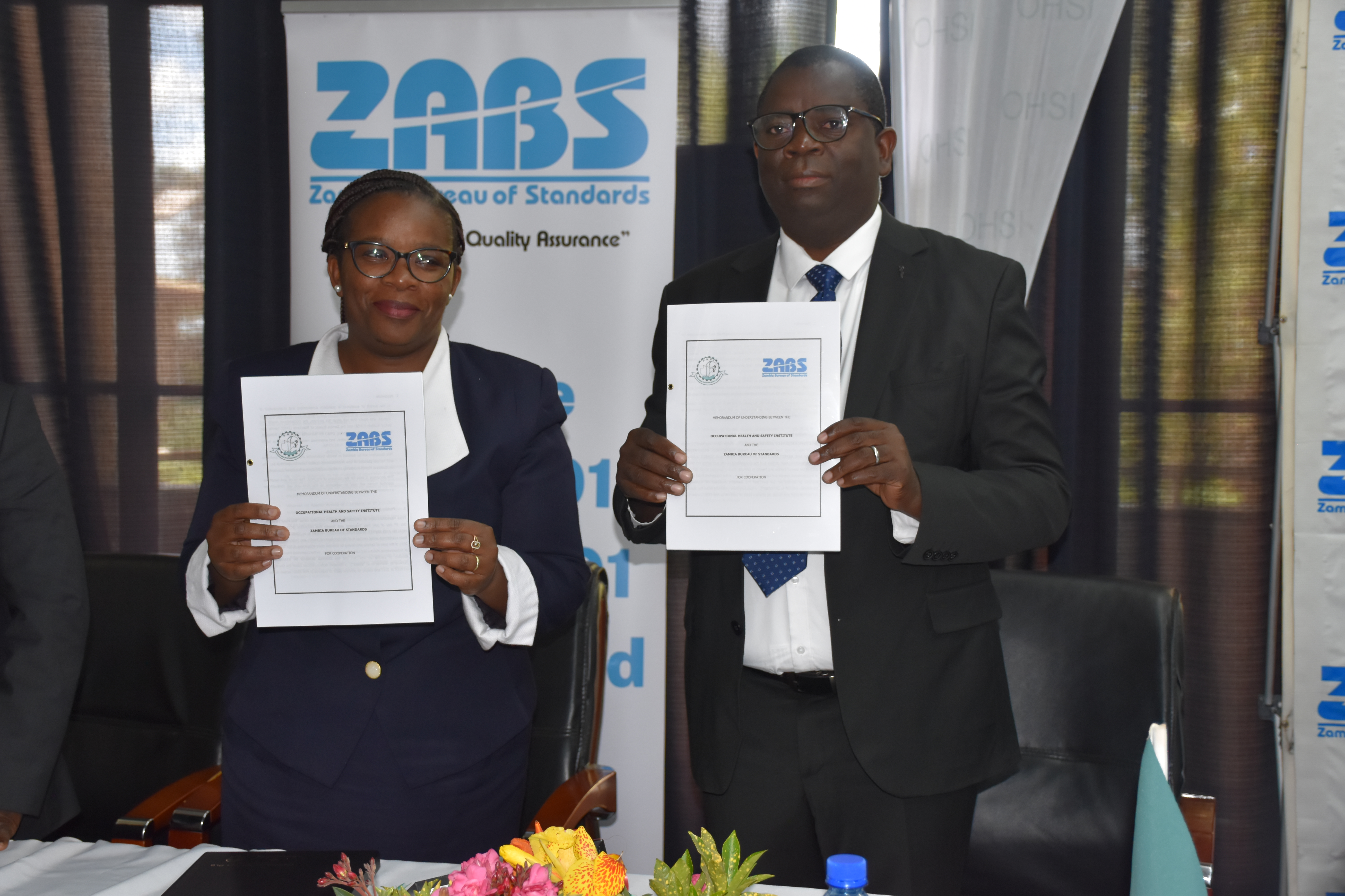 ZABS officials holding signed cooperation documents during a formal agreement event.