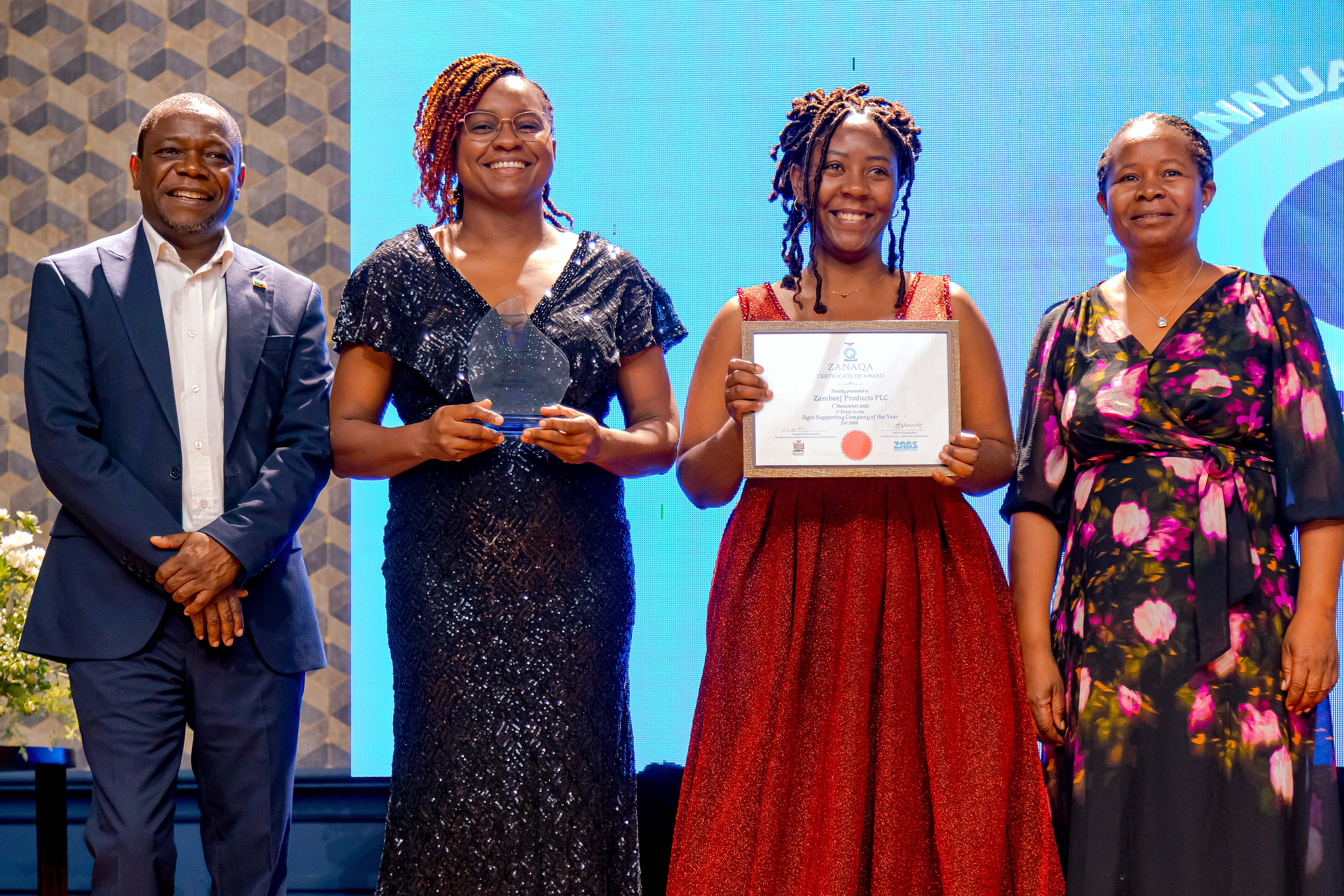 Award recipients posing with a trophy and certificate during the Zambia National Quality Awards.